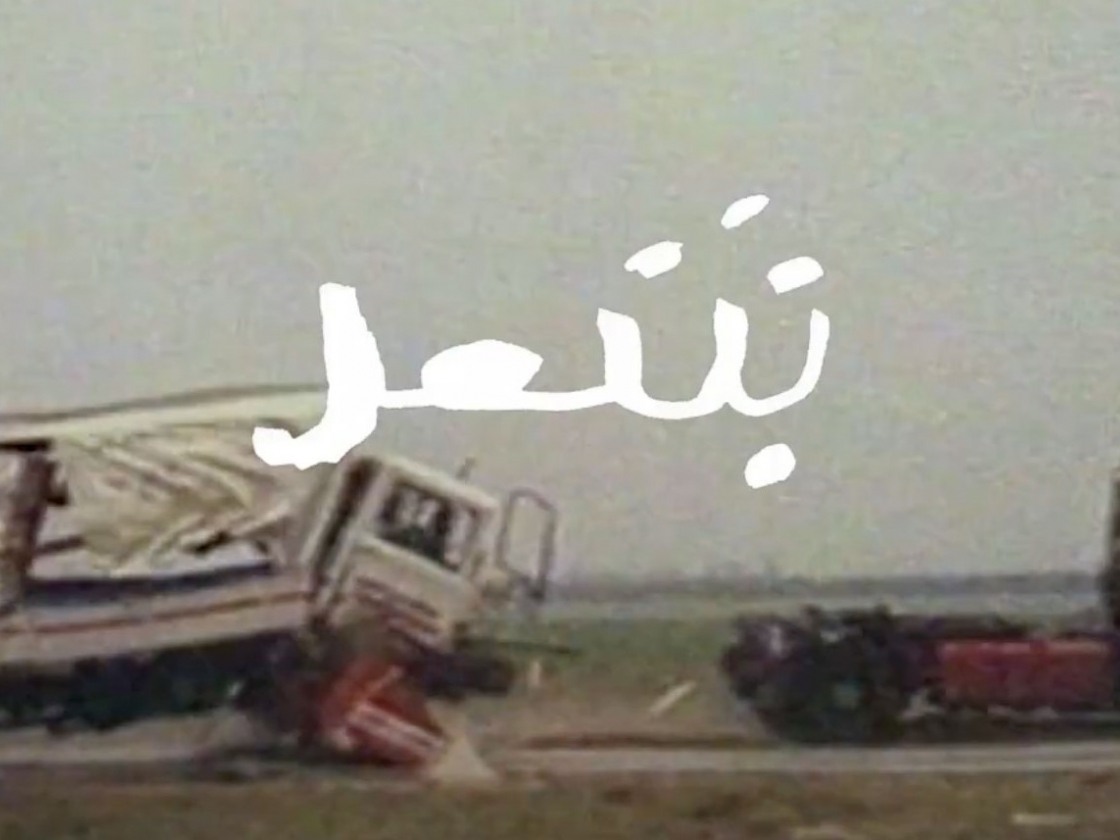 zwei LKW's fahren über eine Straße, eine Zeichenschrift im Vordergrund