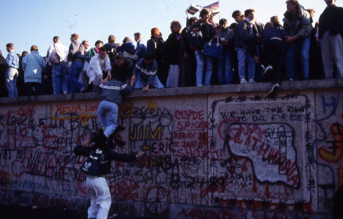 Menschen auf der Berliner Mauer während des Mauerfalls