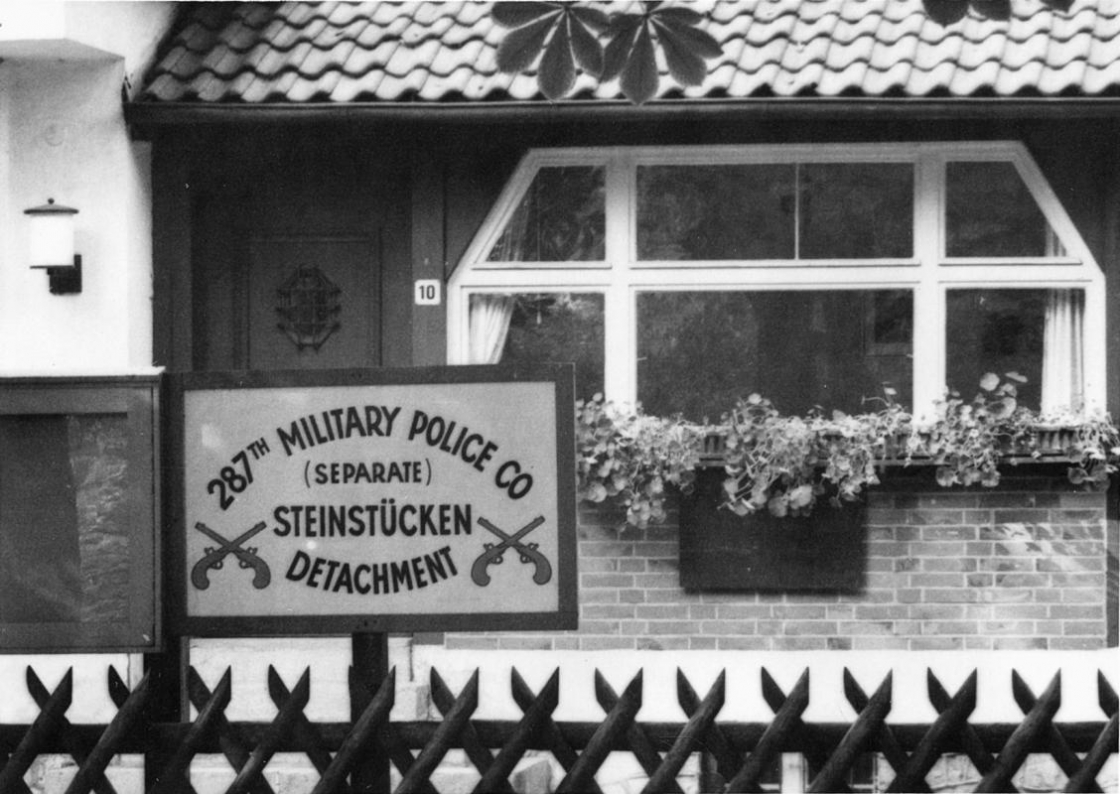 Schild am Zaun vor einem Haus