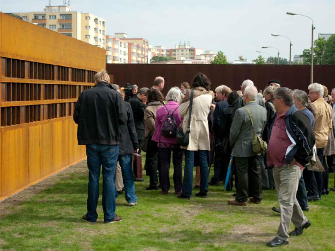 Besucher stehen vor dem neuen Fenster des Gedenkens